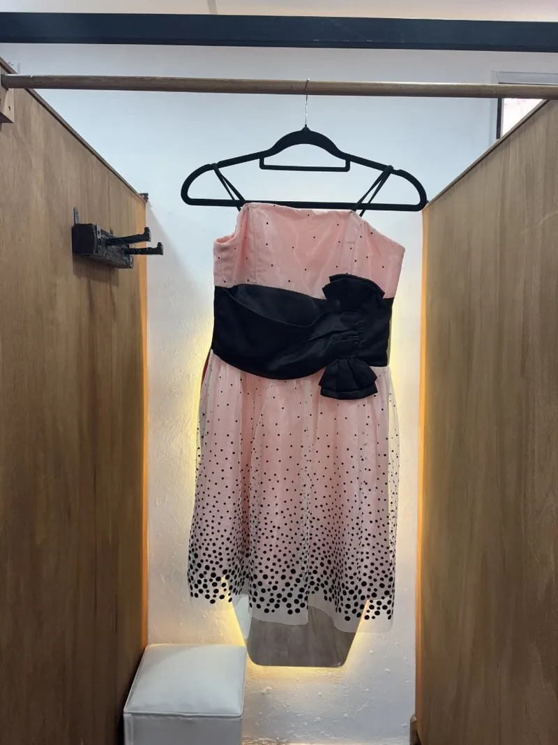Vestido de niña rosa con cinta negra en la cintura